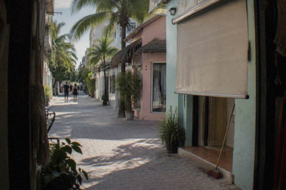 A quiet side street off the main pedestrian avenue with shopfronts opening in the morning