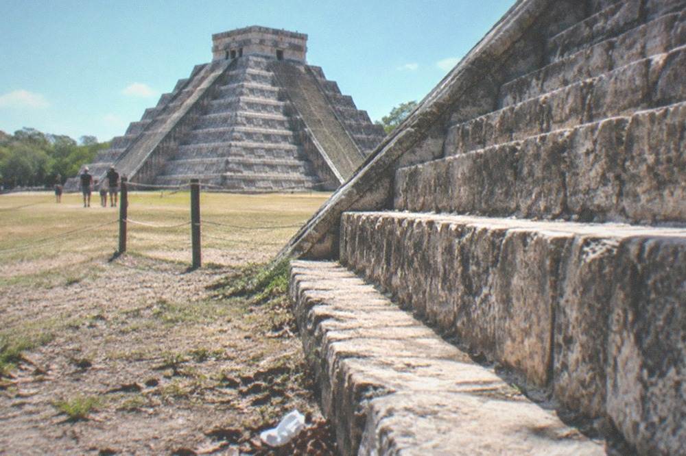 The stone staircase of a tall Maya pyramid under a clear sky at Chichen Itza
